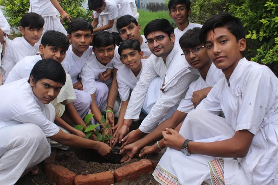 Team planting a sapling with local youth